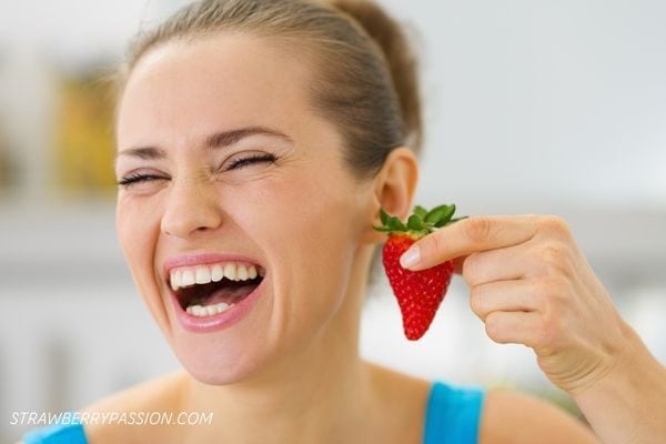 Lady laughing holding a strawberry